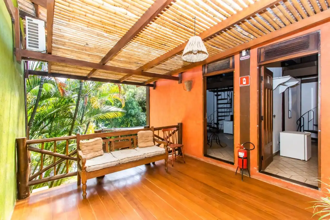 Cozy hotel terrace with wooden furniture and tropical greenery in Ilhabela.