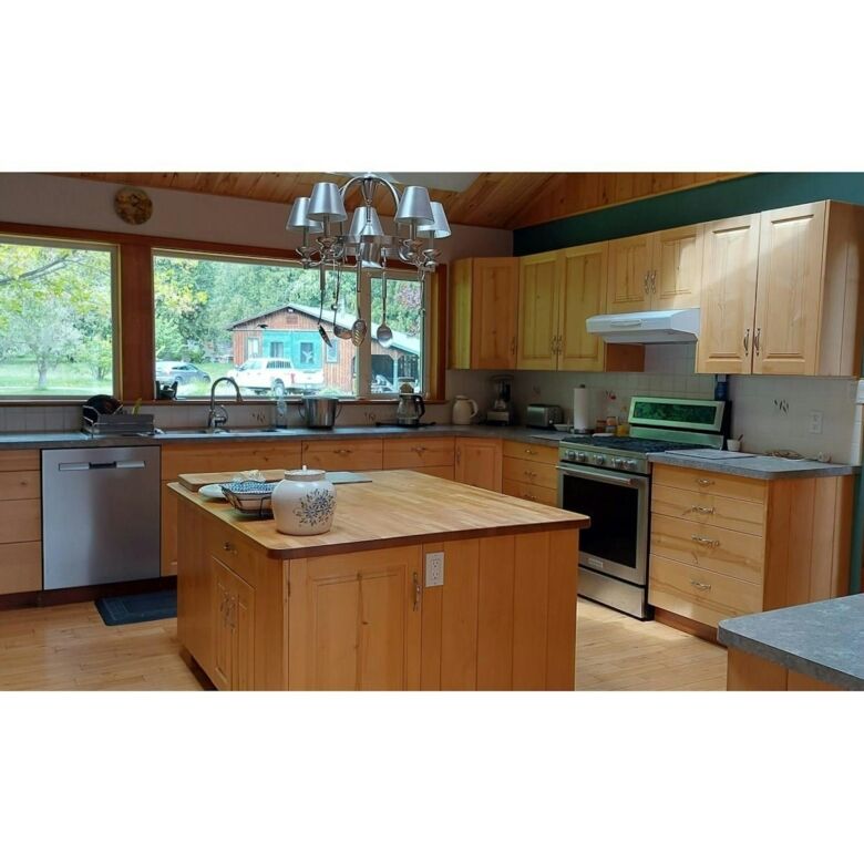 Bright kitchen with wooden cabinets and modern appliances in Bella Coola, British Columbia.
