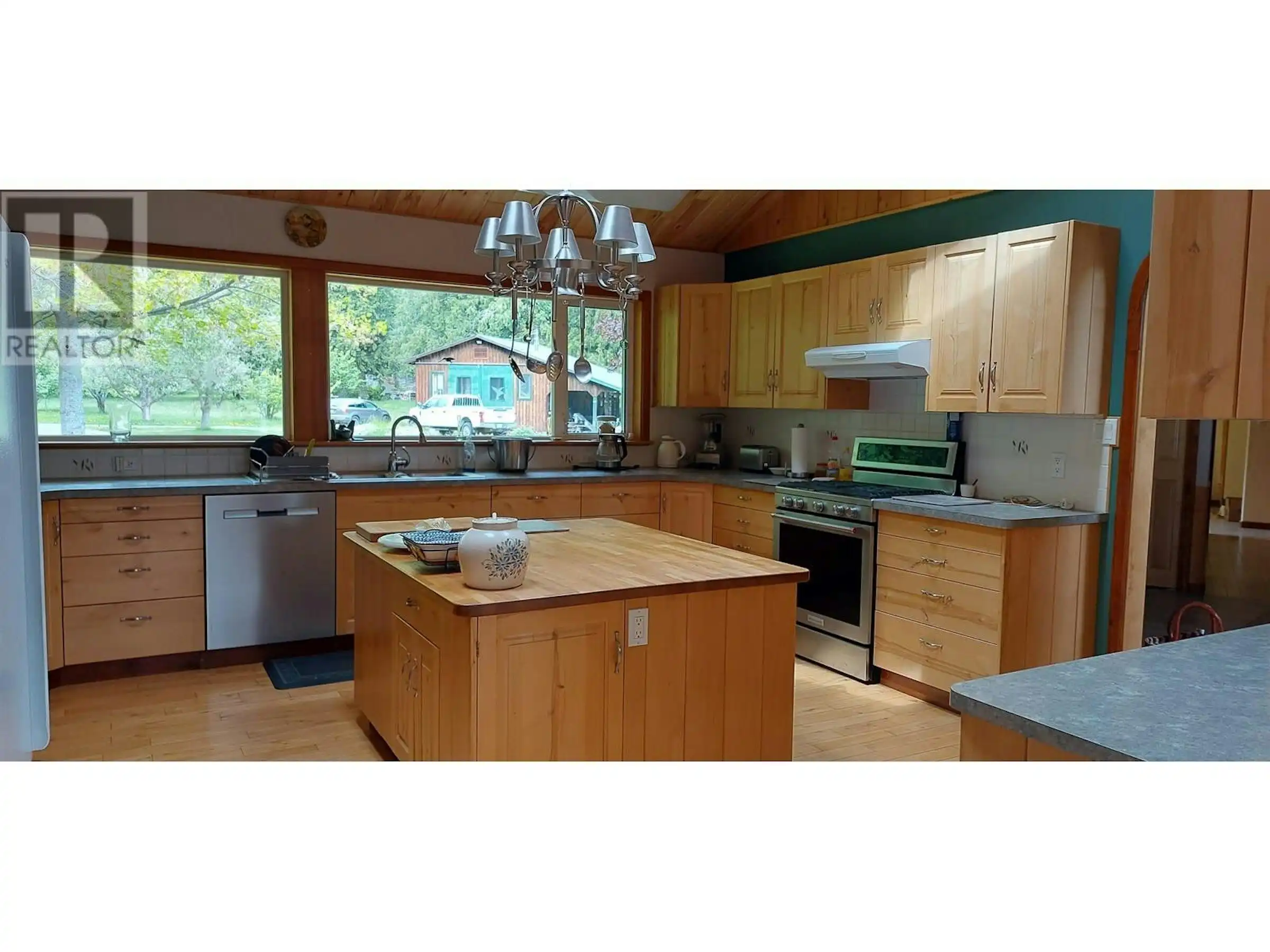 Bright kitchen with wooden cabinets and modern appliances in Bella Coola, British Columbia.