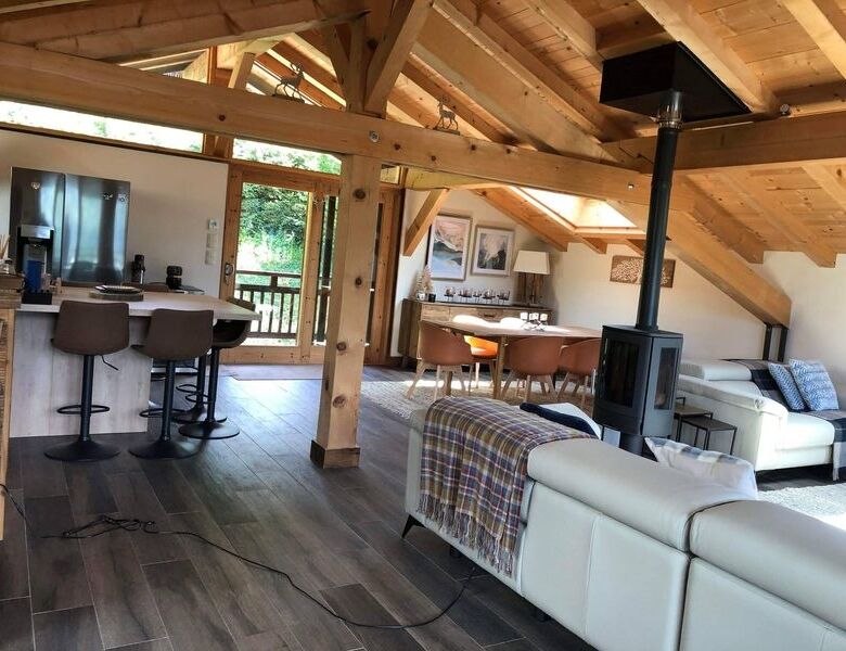 Spacious living area of a luxury 5-bedroom chalet in Samoens with modern furnishings and wooden acce.