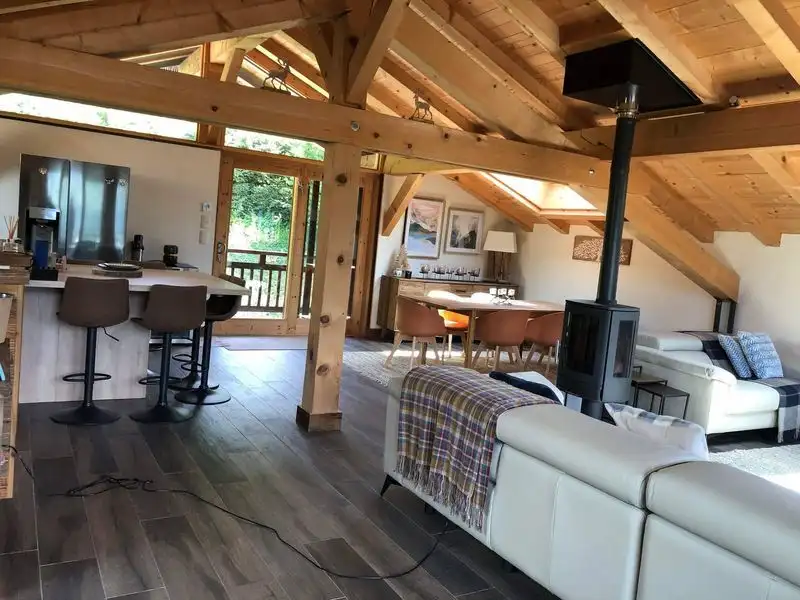Spacious living area of a luxury 5-bedroom chalet in Samoens with modern furnishings and wooden acce.