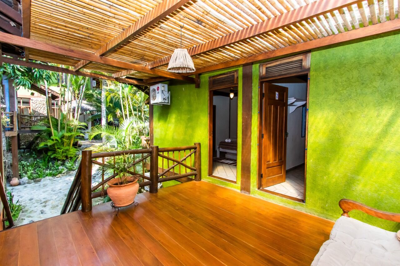 Charming Boutique Hotel in Ilhabela Cozy boutique hotel room with vibrant green walls and wooden accents in Ilhabela. Perfect for a rela.