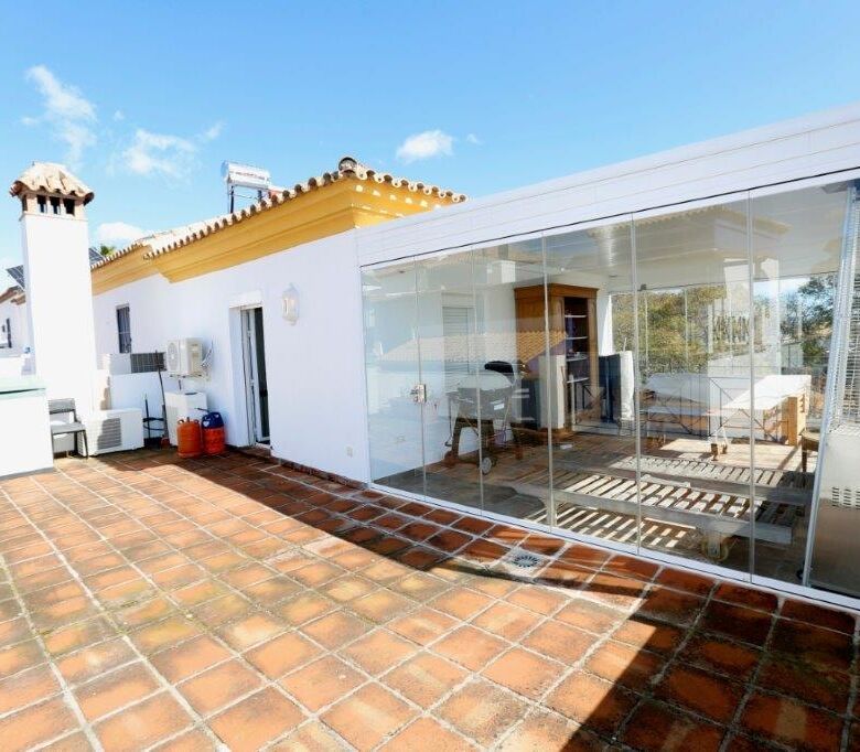 Luxury 4-bedroom house with a glass-enclosed terrace in Marbella, perfect for outdoor living and stu.