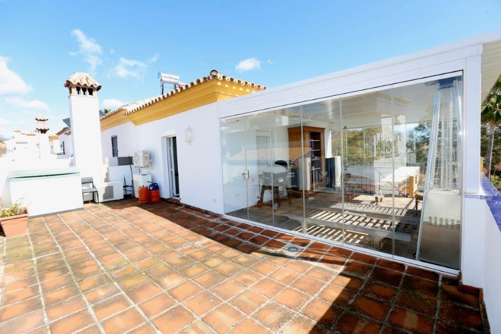 Luxury 4-bedroom house with a glass-enclosed terrace in Marbella, perfect for outdoor living and stu.