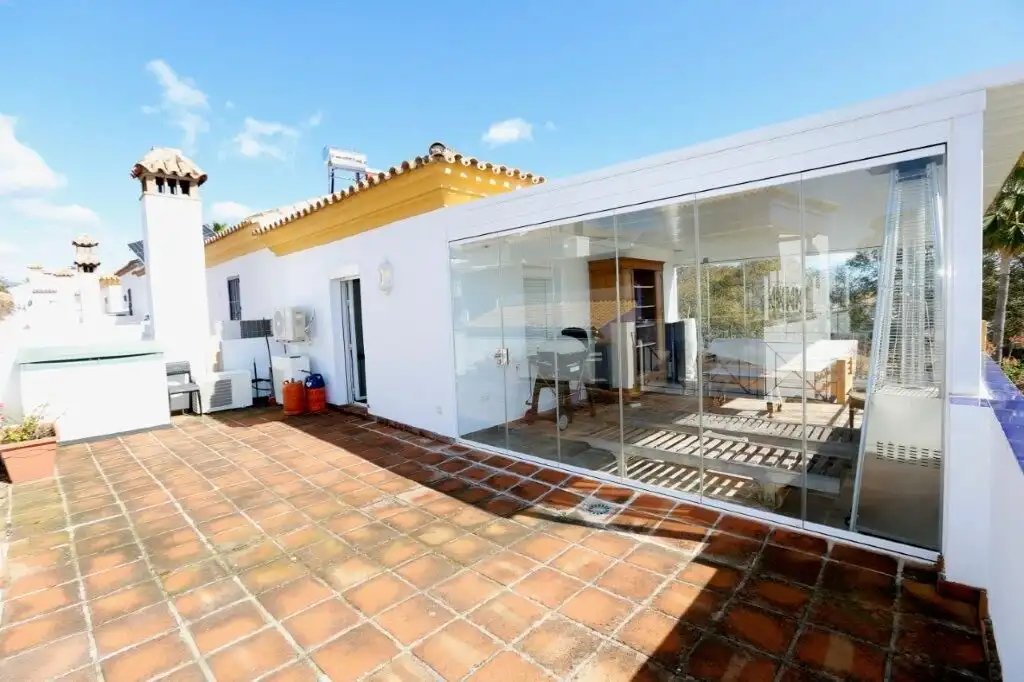 Luxury 4-bedroom house with a glass-enclosed terrace in Marbella, perfect for outdoor living and stu.