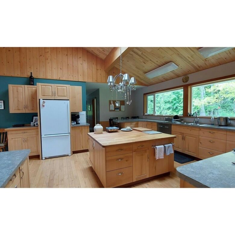 Beautiful kitchen with wooden cabinets and large windows in Bella Coola, British Columbia.