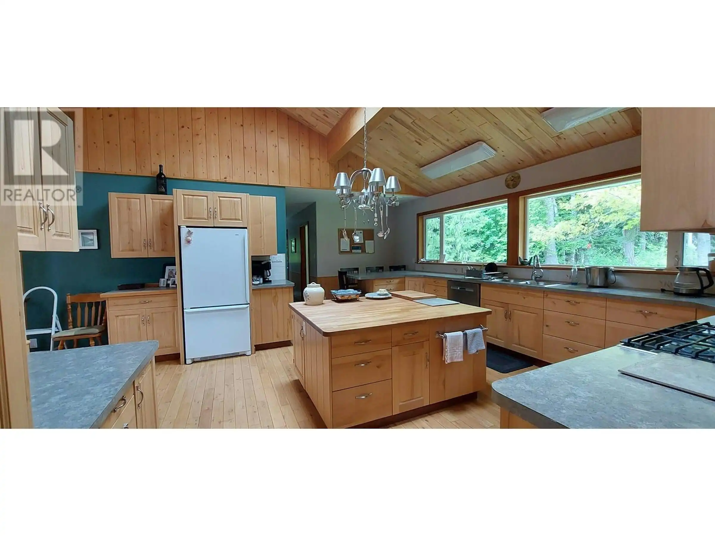 Beautiful kitchen with wooden cabinets and large windows in Bella Coola, British Columbia.