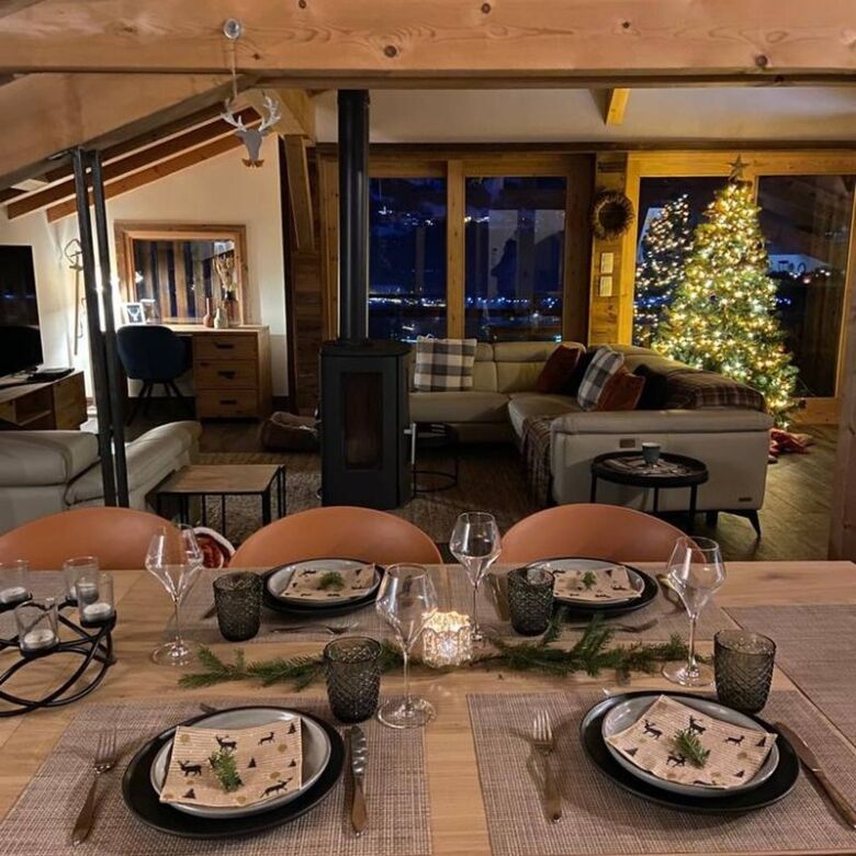 Cozy chalet living room with Christmas tree and large windows in Samoens.