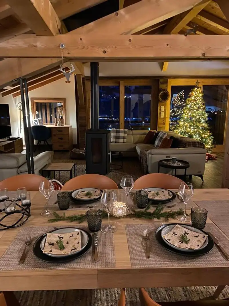Cozy chalet living room with Christmas tree and large windows in Samoens.