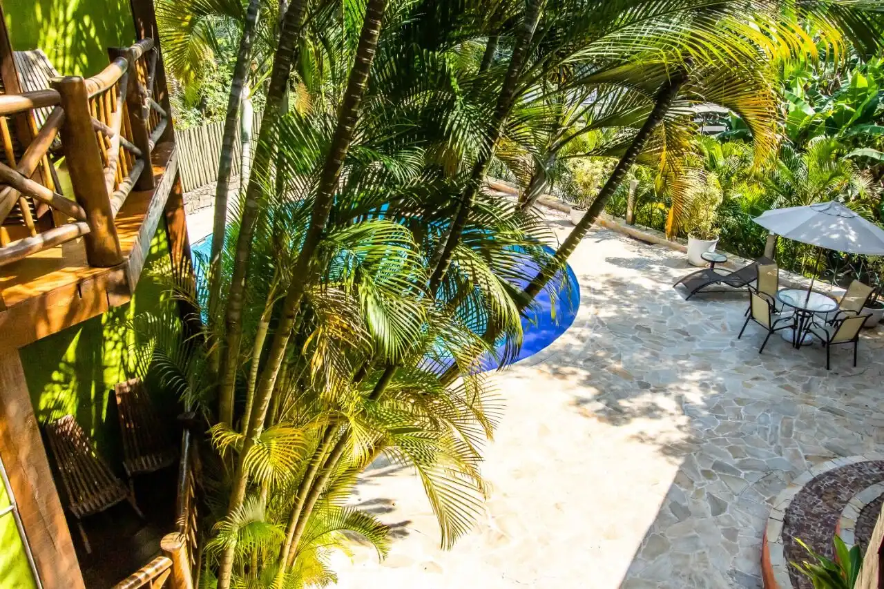 Boutique hotel for sale in Ilhabela surrounded by lush tropical greenery and outdoor pool area.