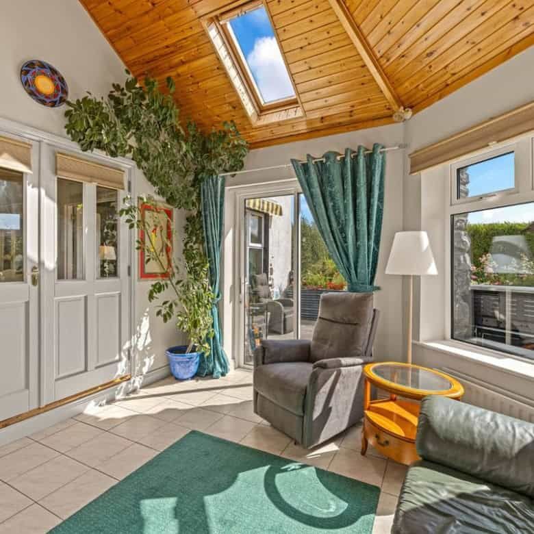 Bright living room with large windows and wooden ceiling.