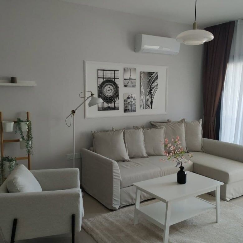 Bright living room with beige sofa, armchair, and balcony view in Caeser’s Resort North.