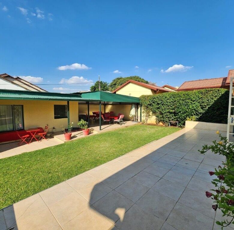 Beautiful backyard of a 4-bedroom house in Albertville Johannesburg South under a clear blue sky.