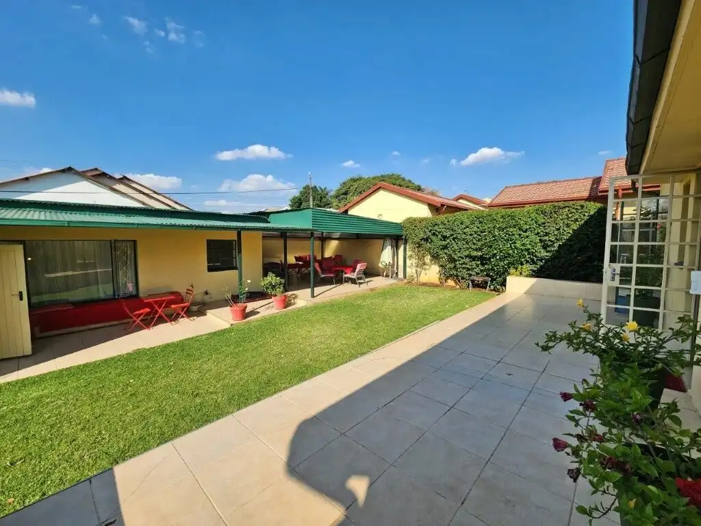 Beautiful backyard of a 4-bedroom house in Albertville Johannesburg South under a clear blue sky.