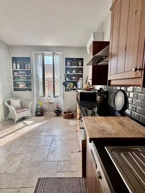 Bright kitchen with wooden cabinets and modern appliances in Allemans-du-dropt.