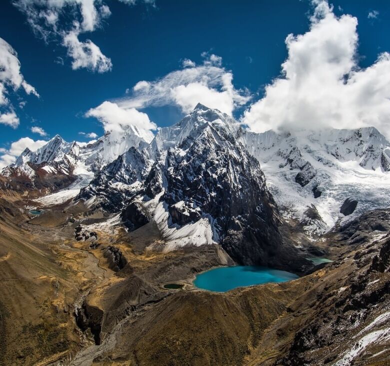 Scenic view of Peruvian Switzerland with mountains, snow, and a turquoise lake.