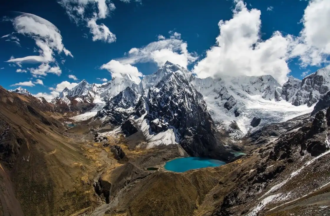 Scenic view of Peruvian Switzerland with mountains, snow, and a turquoise lake.