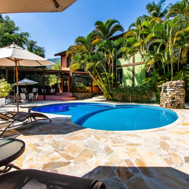 Boutique hotel for sale in Ilhabela featuring a beautiful pool and lush tropical gardens. Perfect in.