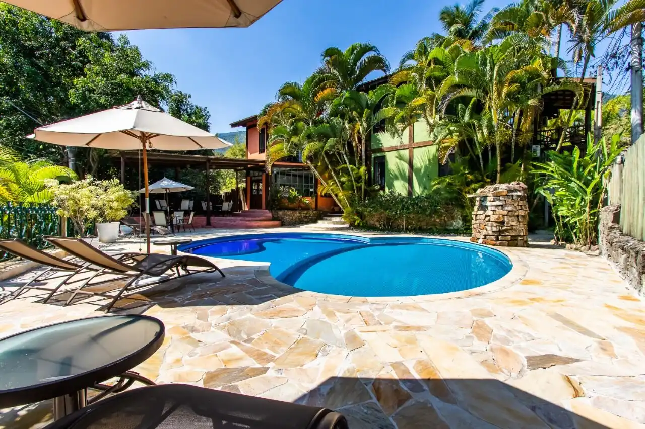 Boutique hotel for sale in Ilhabela featuring a beautiful pool and lush tropical gardens. Perfect in.