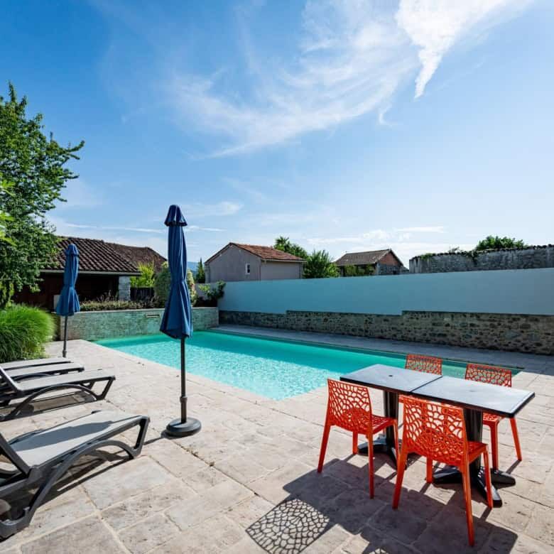 Pool and outdoor seating area at La Maison du Bonheur Bed and Breakfast in Ausson, Haute Garonne.