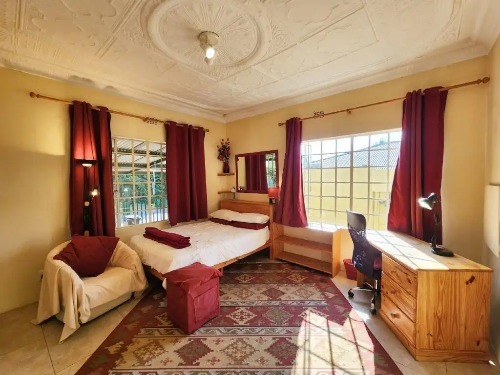 Spacious bedroom with large windows and elegant decor in Albertville, Johannesburg South.