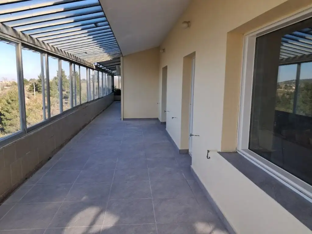 Balcony of a 4-bedroom house in Kapandriti Attica, featuring glass windows and scenic views.