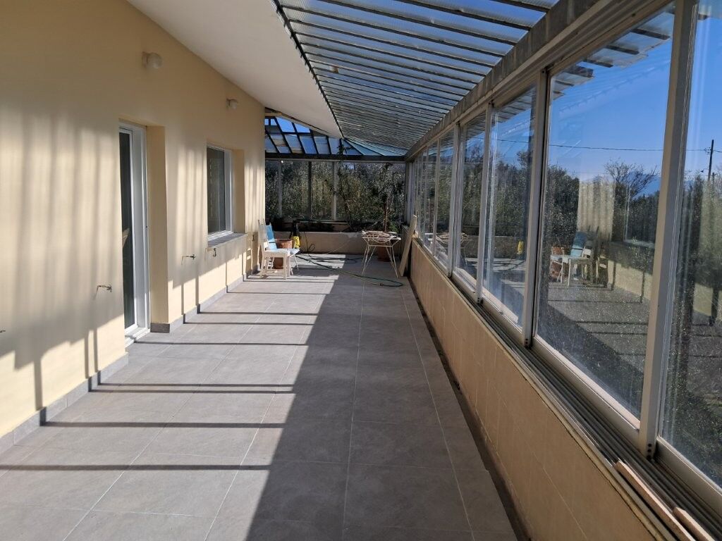Modern 4-Bed House in Kapandriti Attica Spacious balcony with glass enclosure in a 4-bedroom home in Kapandriti, Attica, ideal for comfortab.