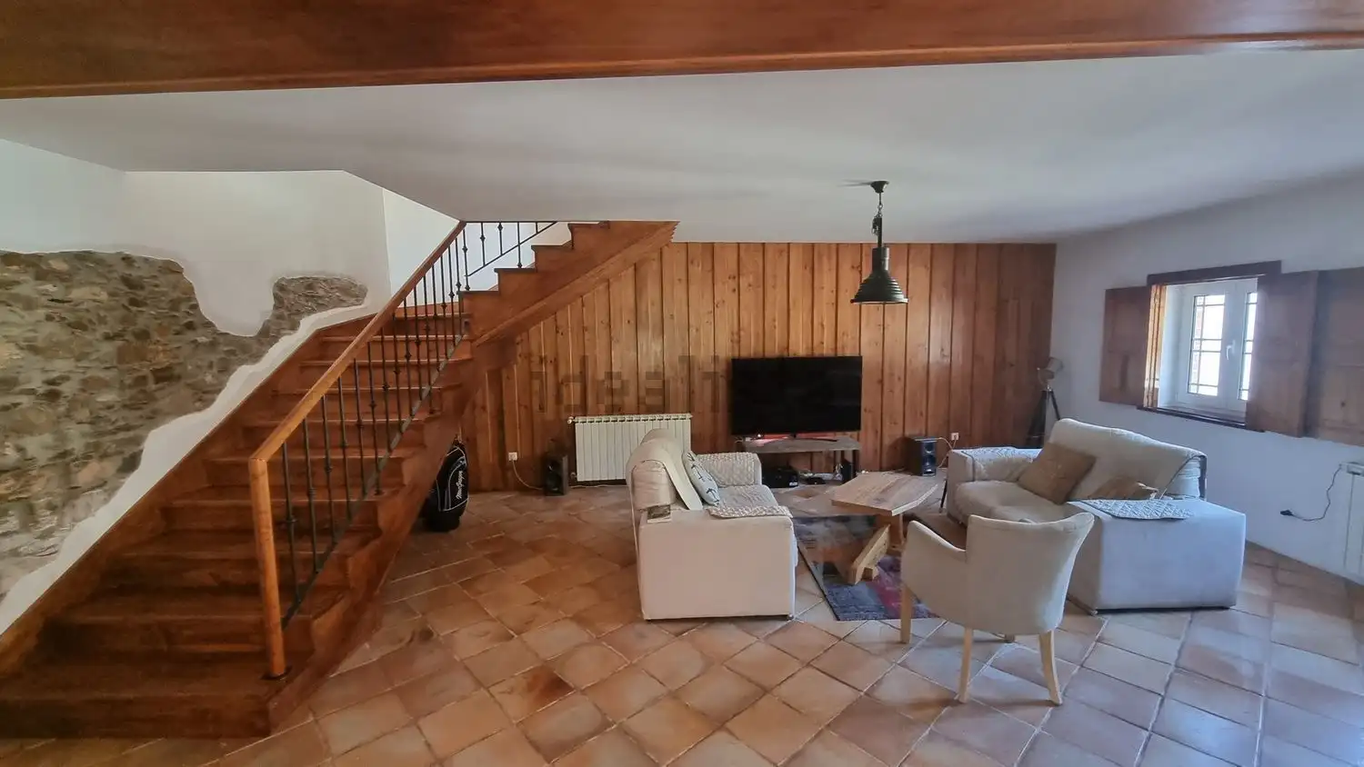 Bright living room with wooden accents and comfortable seating in Cortegaça property.