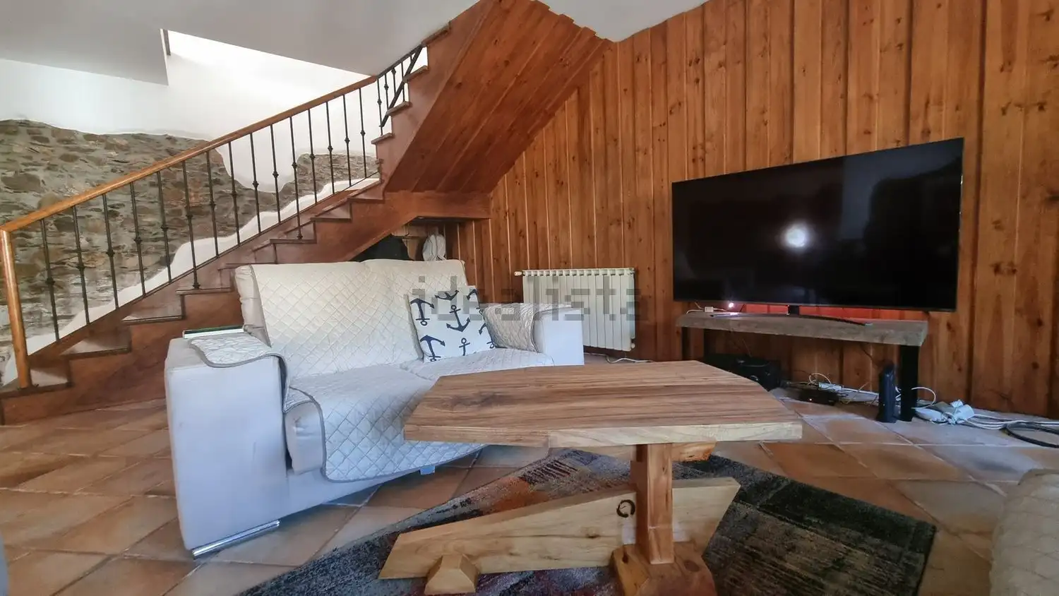 Beautiful living room with wooden accents and modern TV setup in Cortegaça home. Perfect for comfort.