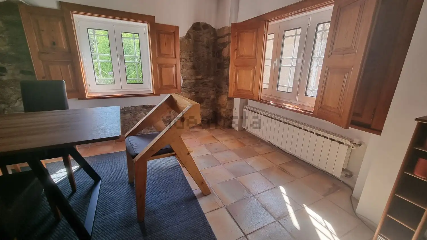 Charming interior of a 4-bedroom house in Cortegaça with wooden window shutters and natural light.
