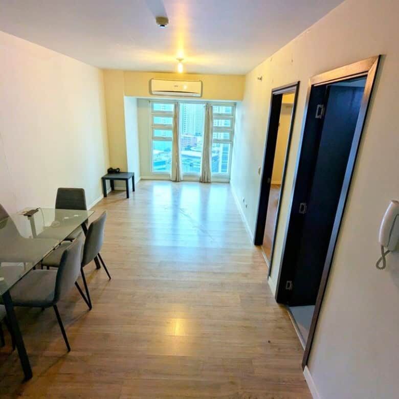 Bright interior of a 1-bedroom apartment in Kroma Tower Manila with large windows and city views.
