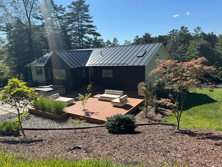 Beautiful contemporary house in Hanover, New Hampshire, featuring a spacious outdoor deck and lush g.