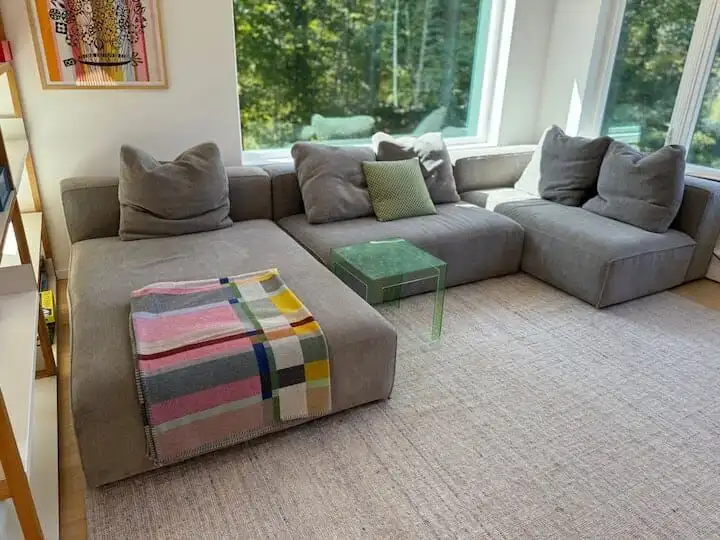 Spacious living room with large sectional sofa and natural light in Hanover, New Hampshire.