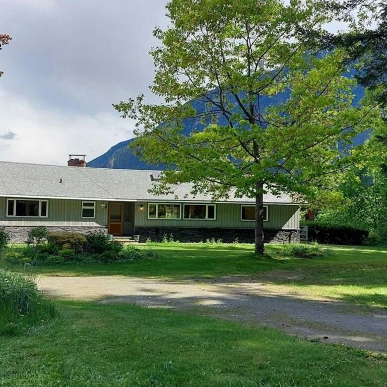 Beautiful 4-bedroom estate in Bella Coola, British Columbia, surrounded by lush greenery and mountai.