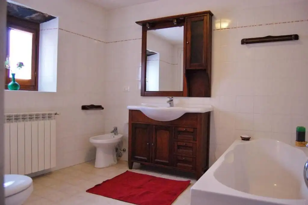 Spacious bathroom with bathtub, sink, and toilet in a luxurious Bagni di Lucca property.