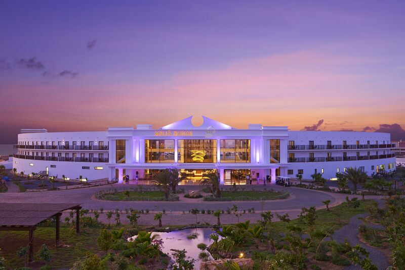 Luxury Dunas Beach Resort Hotel Modern hotel at sunset with vibrant lighting and lush gardens.