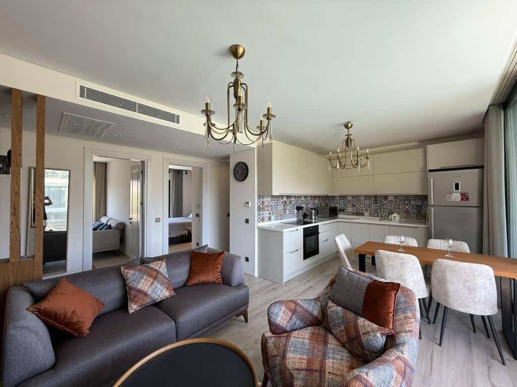 Spacious living room with open-plan kitchen and stylish furnishings in a luxury Yalıkavak Bodrum apa.