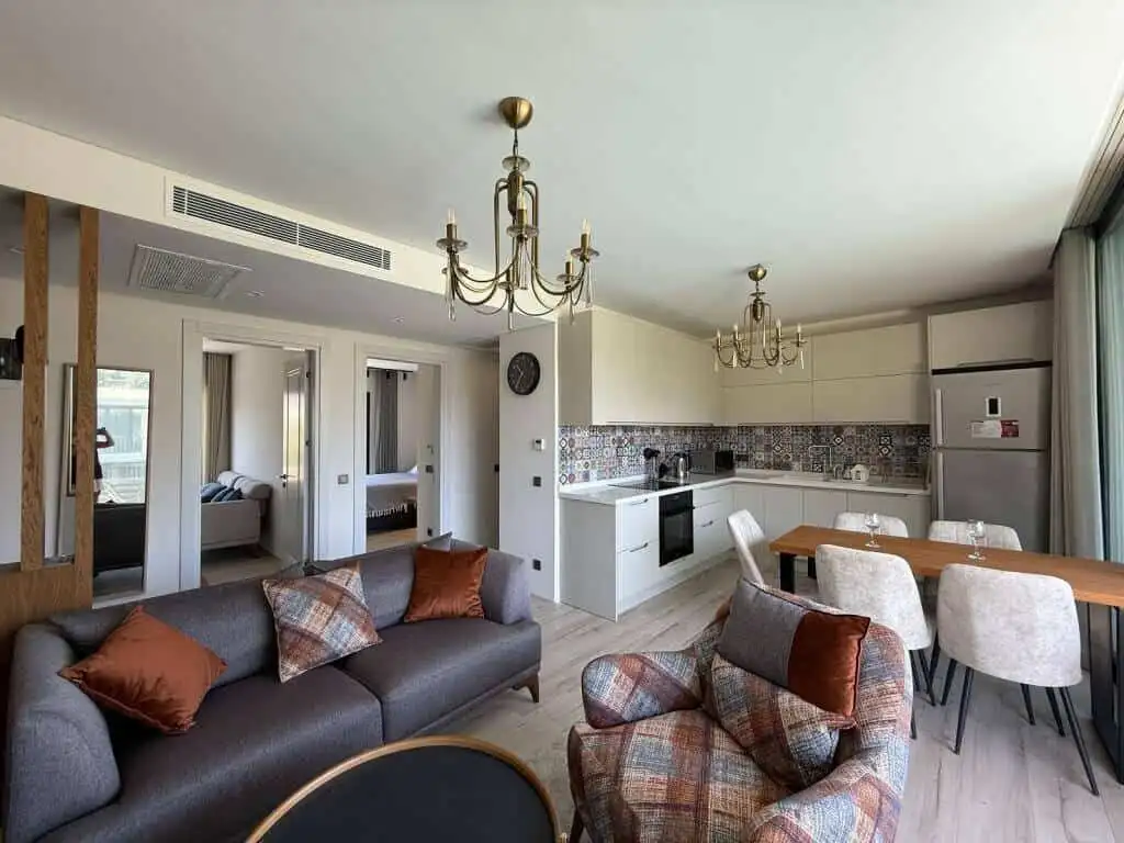Spacious living room with open-plan kitchen and stylish furnishings in a luxury Yalıkavak Bodrum apa.