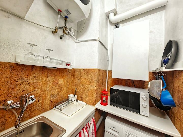 Small kitchen with microwave, sink, and water heater in Bordighera Alta apartment.