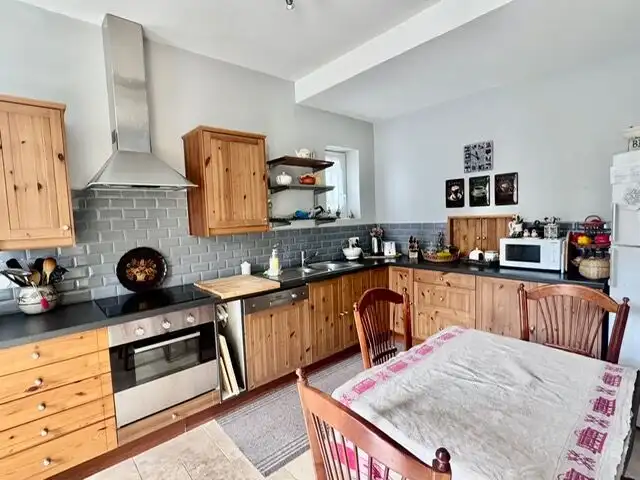 Bright kitchen with wooden cabinets and modern appliances in a luxury townhouse.