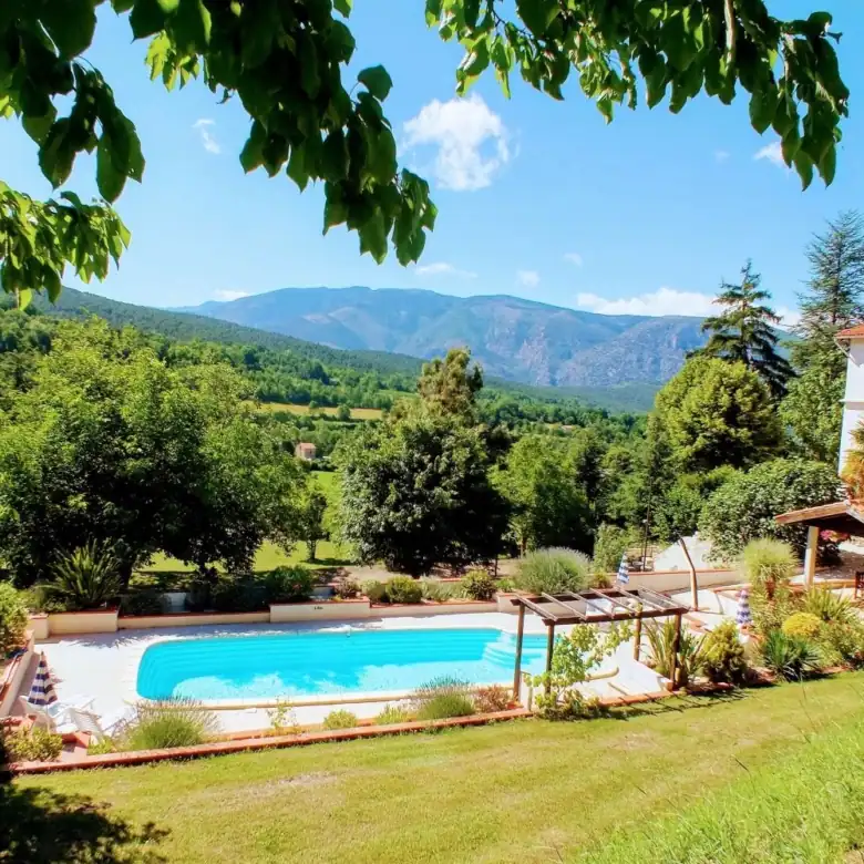 Spacious outdoor pool at La Chataigneraie Gite Complex in Sahorre, surrounded by lush greenery.