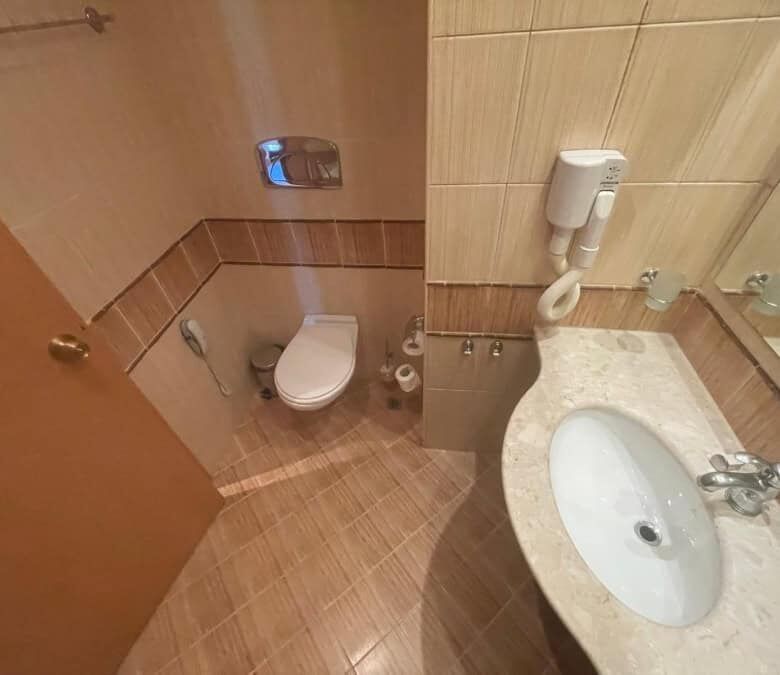 Cozy bathroom in a ground-floor apartment at Majestic, Sunny Beach, featuring a toilet and sink.