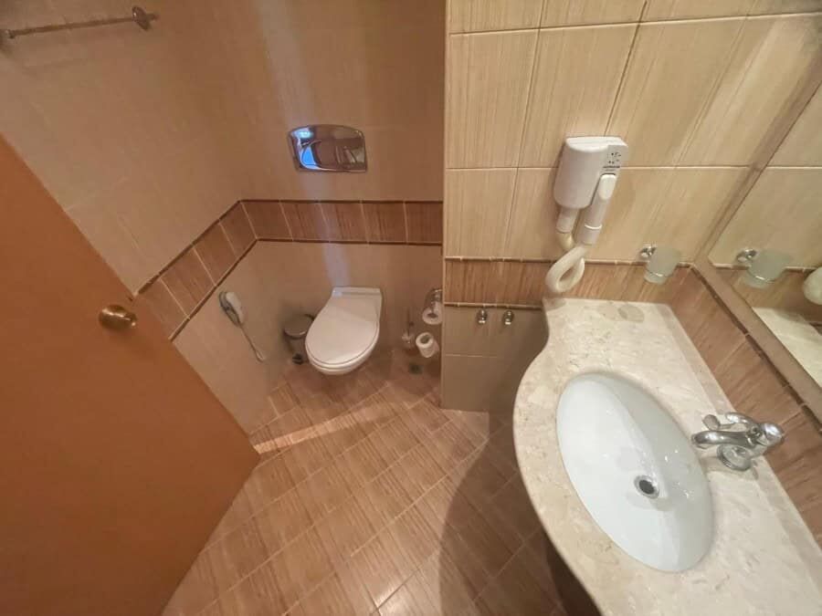 Cozy bathroom in a ground-floor apartment at Majestic, Sunny Beach, featuring a toilet and sink.