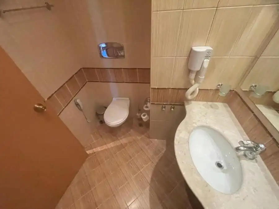 First line apartment, 64 sq.m., ground floor in Majestic (Sunny beach) Cozy bathroom in a ground-floor apartment at Majestic, Sunny Beach, featuring a toilet and sink.