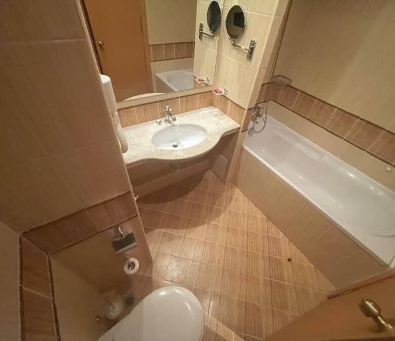 Bathroom with bathtub, sink, and toilet in a cozy apartment.