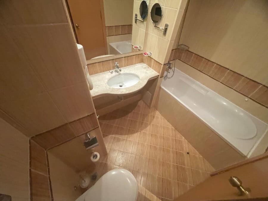 Bathroom with bathtub, sink, and toilet in a cozy apartment.