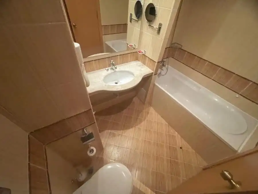 Modern bathroom with bathtub and sink in a compact apartment. Bathroom with bathtub, sink, and toilet in a cozy apartment.