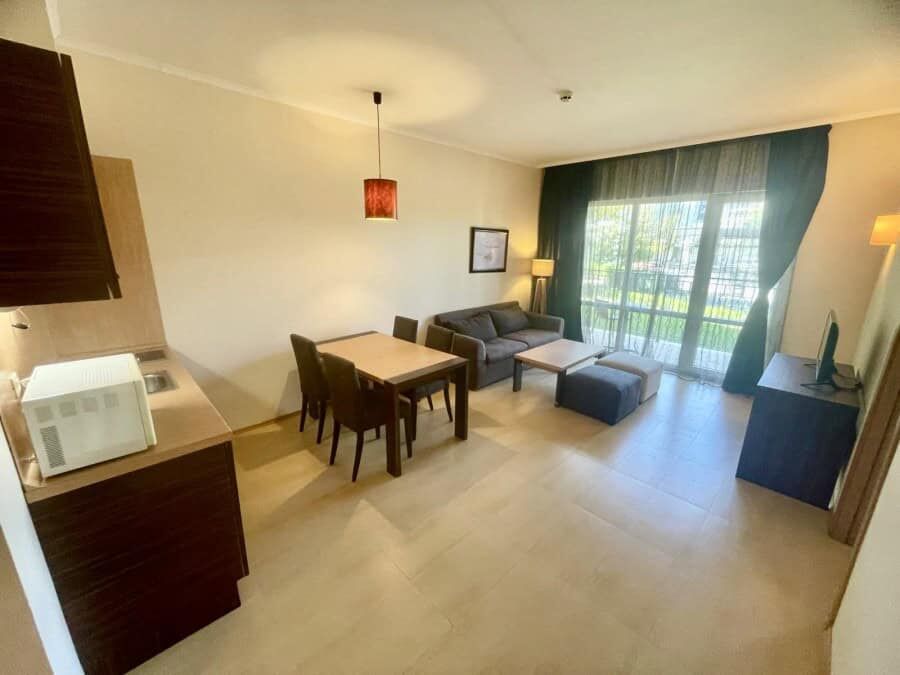 Bright living room with large windows and balcony access.