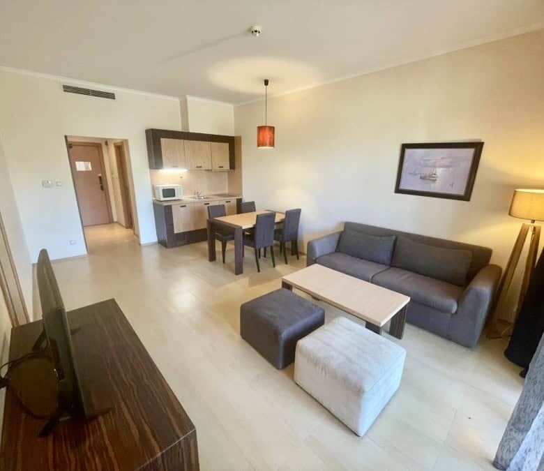 Bright living room of a 1-bedroom apartment in Majestic, Sunny Beach, with sofa, dining area, and ki.