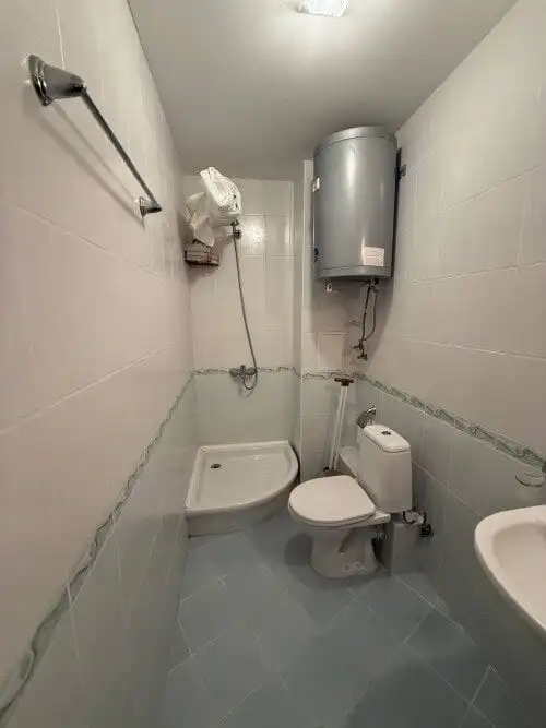 Compact bathroom with toilet, shower, and water heater in Vineyards SPA Resort.